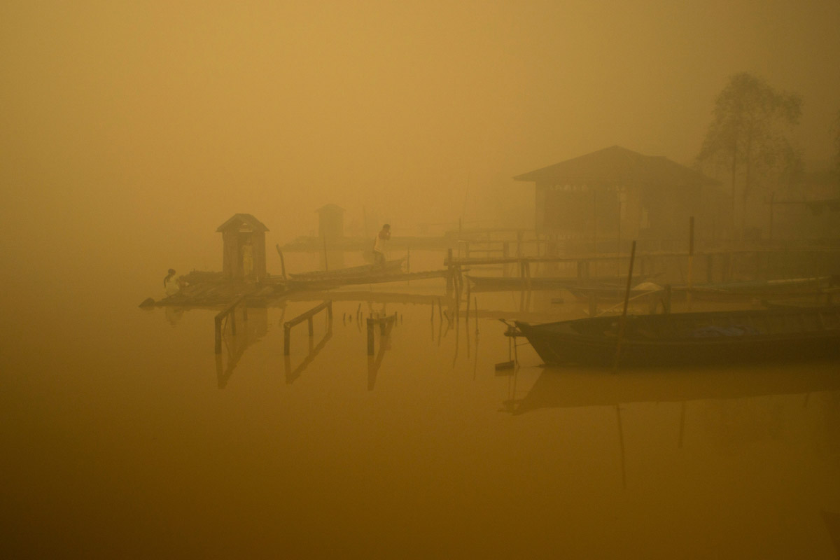 Members of the indigenous community live at the riverbanks in Kapuas river where the air is engulfed with thick haze at Sei Ahass village, Kapuas district, Central Kalimantan province on Borneo island, Indonesia. These fires are a threat to the health of millions.